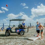 Family playing games on the beach next to golf cart rental in Port Aransas