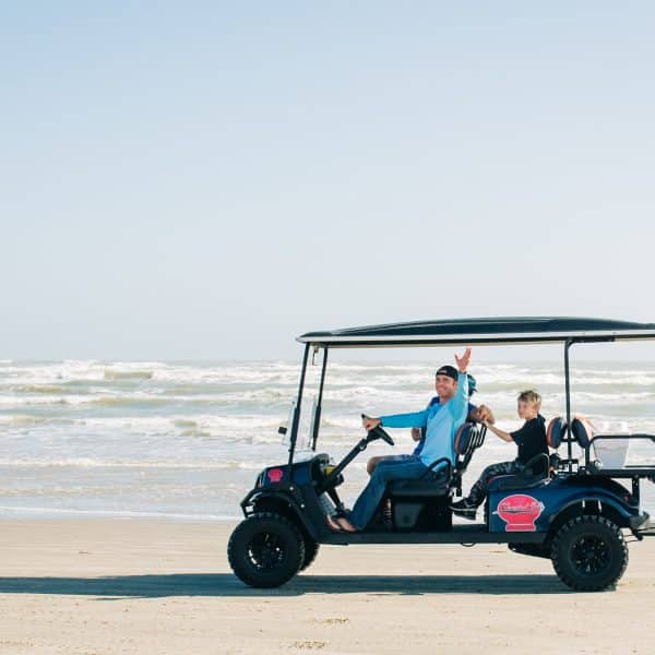 Man driving golf cart on the beach 