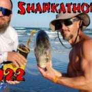 2 men holding shark bait while shark fishing
